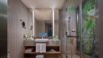 Une salle de bain moderne avec une douche, un lavabo et un miroir. On trouve des serviettes et des articles de toilette sur le comptoir.