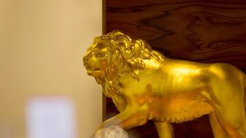A golden lion statue in a room with wooden paneling.
