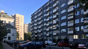 A multi-story residential building with balconies, parked cars, and a clear sky. - Plac Teatralny - Imaginea City Apartments (Warsaw)