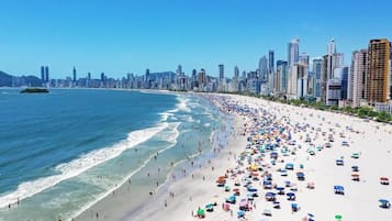 Una playa con el horizonte de una ciudad al fondo.