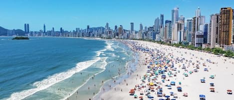 Ein Strand mit einer Stadtansicht im Hintergrund.