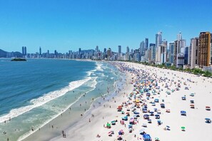 A beach with a city skyline in the background. - Hotel Brasil Express (Balneário Camboriú)