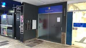 L'ingresso di un hotel con un cartello blu che riporta la scritta "Brasil Express Hotel" e il numero civico "1650".