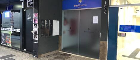 A hotel entrance with a blue sign reading "Brasil Express Hotel" and a door number "1650".