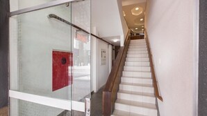 Una scala moderna con un pannello in vetro sulla sinistra e una ringhiera in legno.