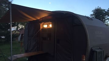 A RV with a covered sleeping area, a small kitchenette, and a visible TV.