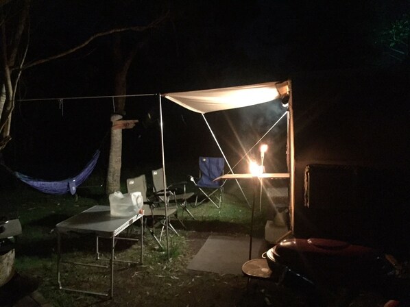 A campsite with a tent, a hammock, and camping chairs.