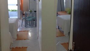 A hotel corridor with a bed, a dining area, and a view of the sea. - Bahia Flat Studio (Salvador)