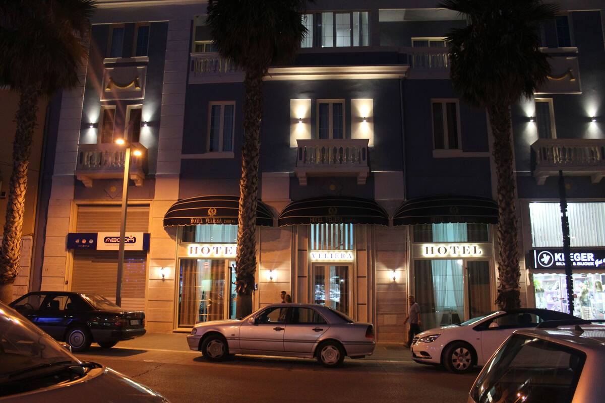 A hotel with a classic facade, featuring multiple balconies and a prominent entrance.