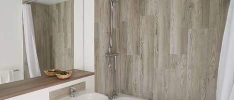 A modern bathroom with a wooden wall, a bathtub, a sink, and a shower.