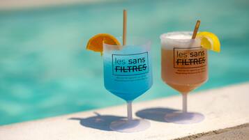 Two drinks with labels 'les sans filtres' by a poolside.