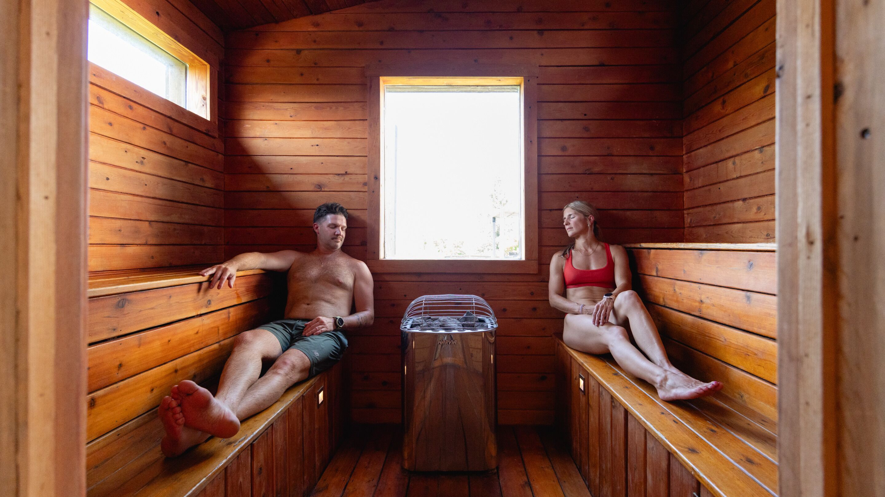 A sauna with wooden benches and a central heating unit.