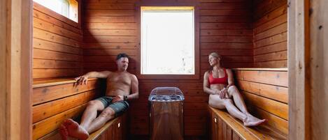 A sauna with wooden benches and a central heating unit.