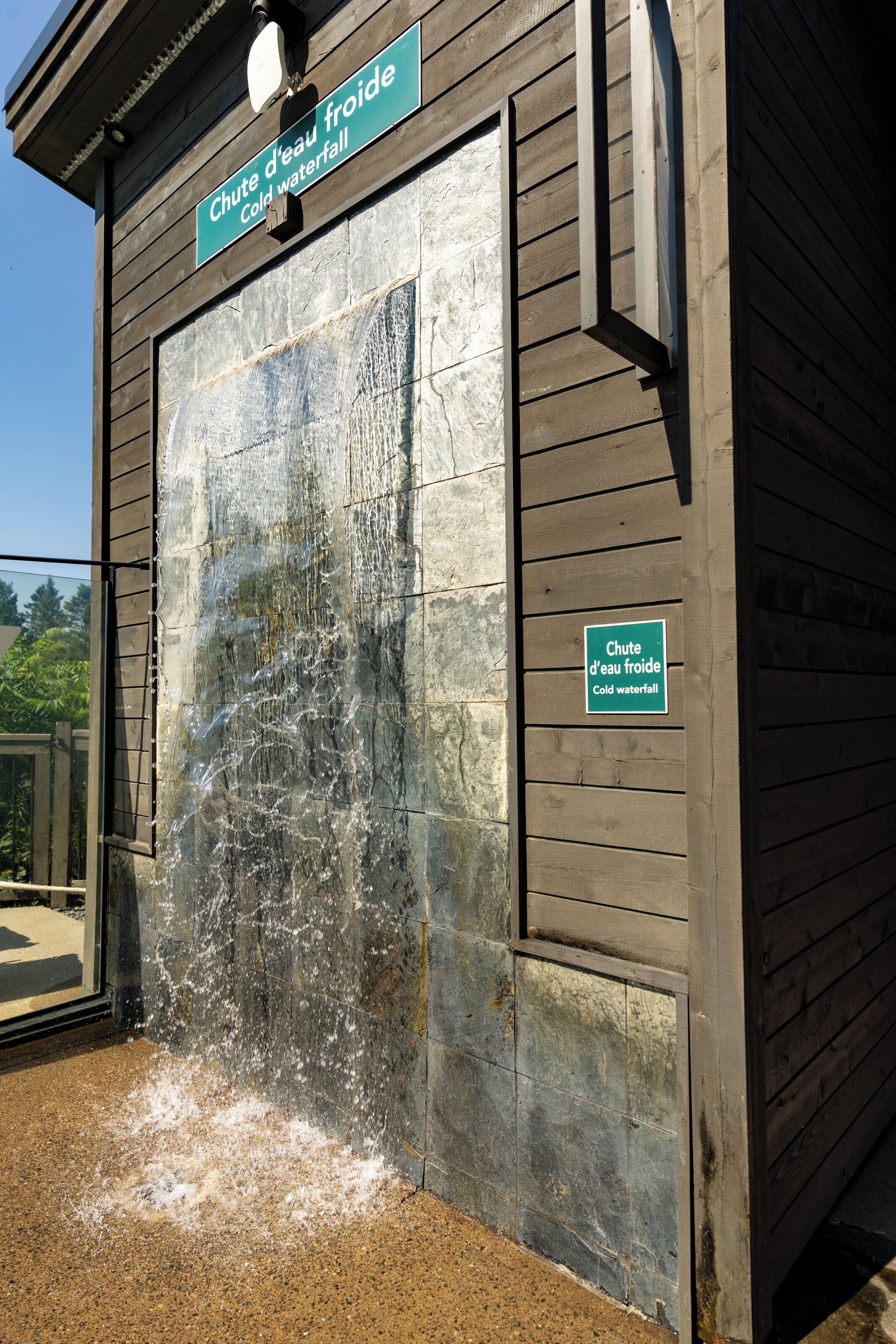 A wooden building with a sign indicating a cold waterfall feature.