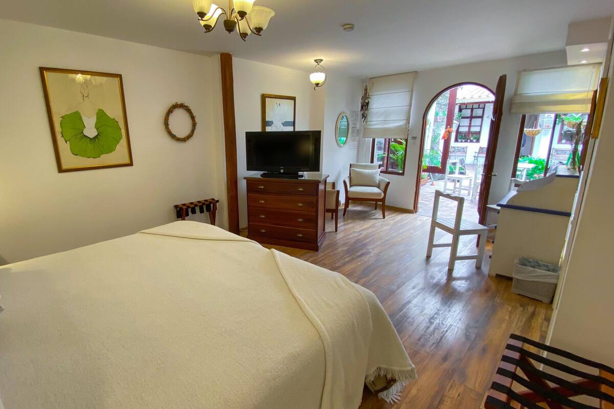 A hotel room with a bed, a dresser, a television, and a chair.