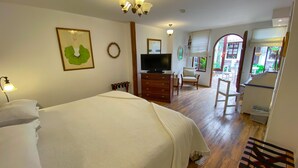 Une chambre d’hôtel avec un lit, une commode, une télévision et une chaise.