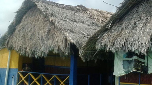 Wasserbungalows mit strohgedeckten Dächern und Wasserstand, der die unteren Fenster erreicht.