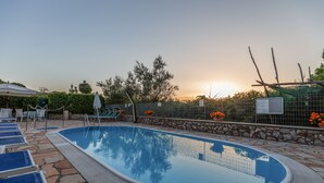 A swimming pool with lounge chairs and a stone pathway. - Hotel La Pergoletta (Massa Lubrense)