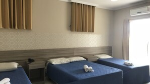 A hotel room with two beds, a desk, and an air conditioning unit. - Pratico Hotel (Santarém)