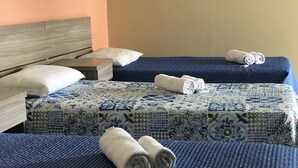 A hotel room with two beds, each with a blue quilt and rolled towels. - Pratico Hotel (Santarém)