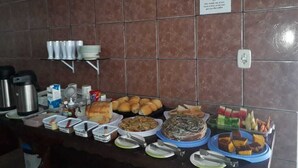 Disposição de buffet com diversos alimentos e utensílios.
