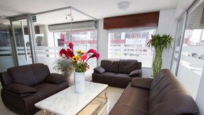 Ein moderner Wartebereich mit Ledersofas, einem Marmortisch und einer Blumenvase.
