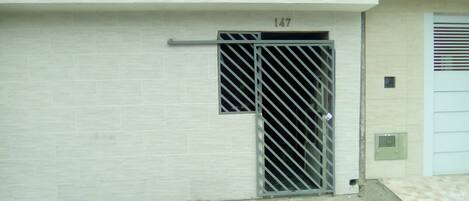 A building with a numbered door (147) and a metal gate.