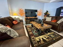 A living room with a brown sofa, a wooden coffee table, and a patterned rug.