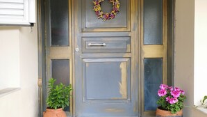 A front door with a wreath, a doormat, and two potted plants. - Villa Irene (Kos)