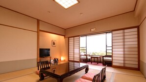 A traditional Japanese-style room with tatami flooring, a low table, and sliding doors. - Yufuin Sansuikan (Yufu)