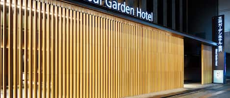 The exterior of the Mitsui Garden Hotel with a modern facade and illuminated signage.