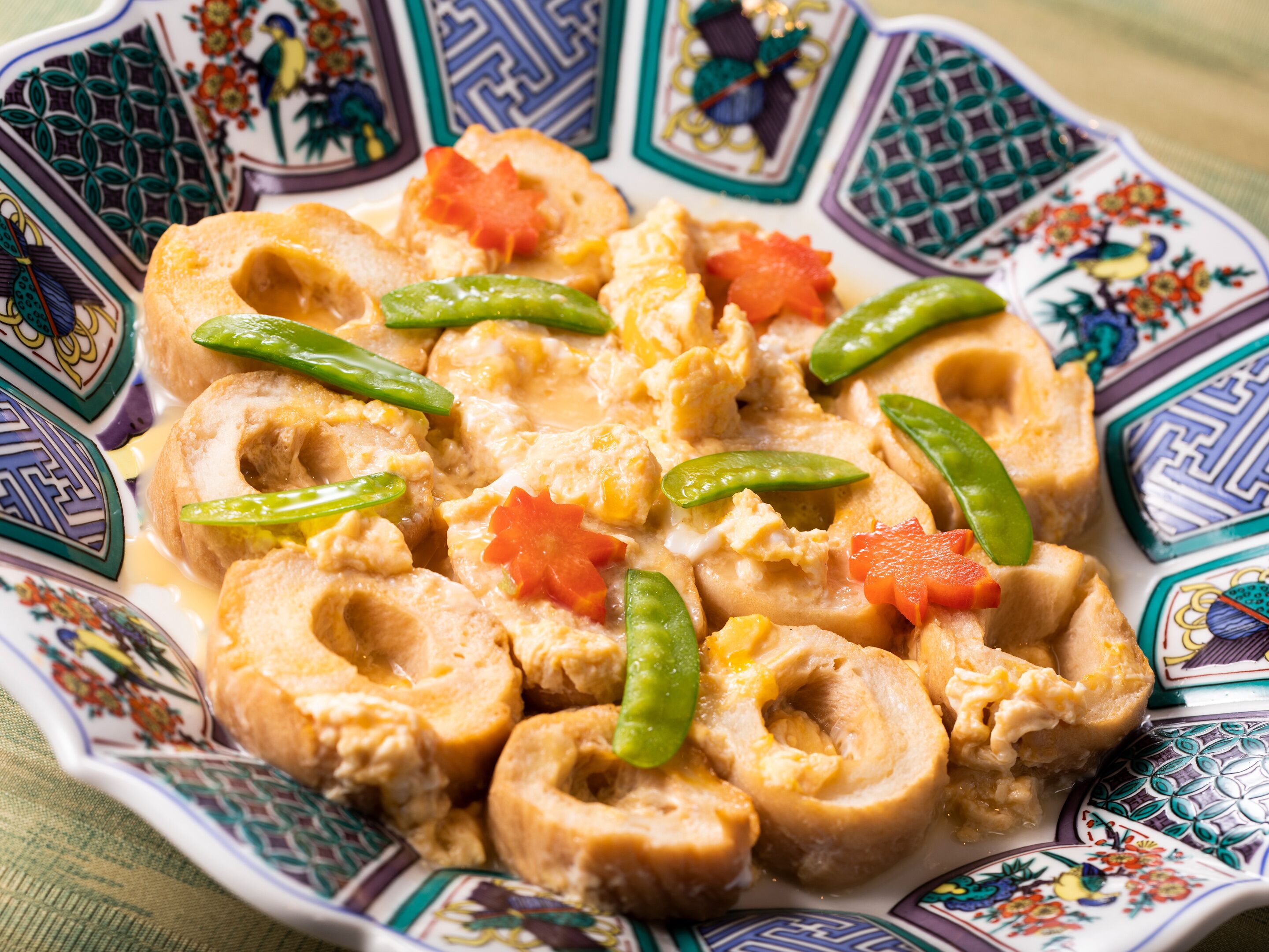 A plate of food with various vegetables and a creamy sauce.