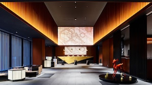 A spacious lobby with a reception desk, seating areas, and a decorative sculpture. - Mitsui Garden Hotel Kanazawa (Kanazawa)