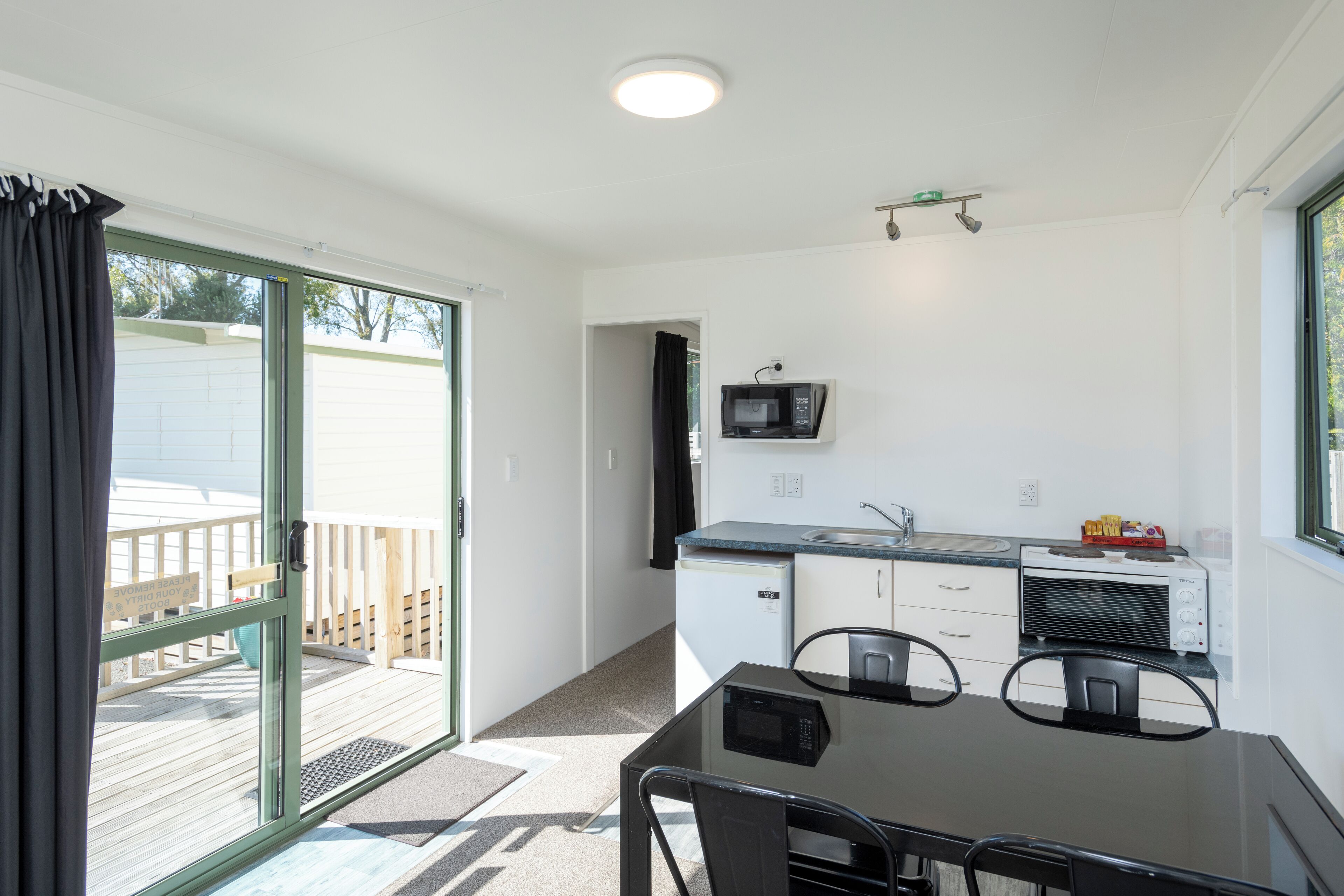 A compact kitchen with a microwave, toaster, and sink.