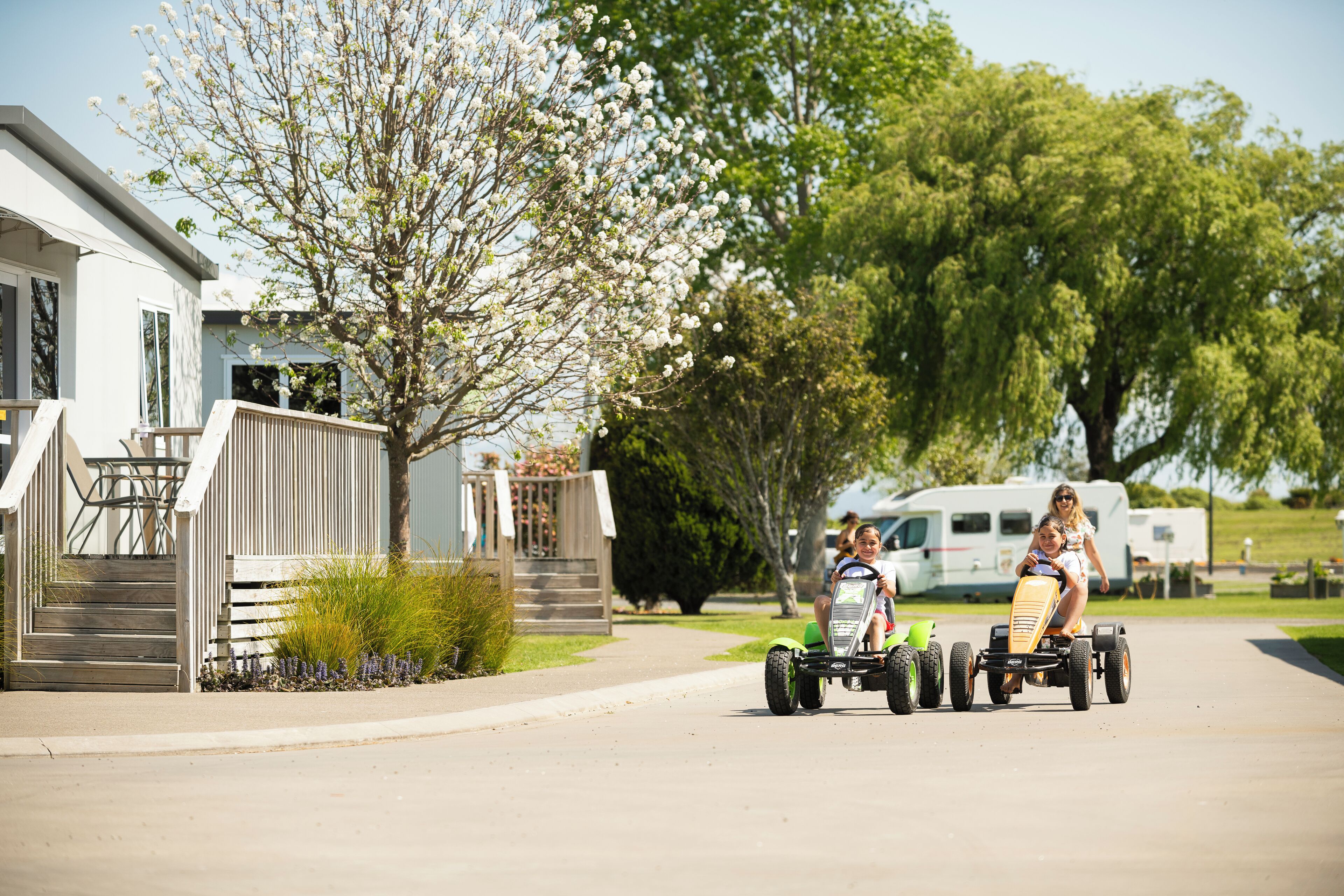 A residential street with a house, a driveway, and a trailer.