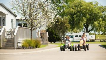 A residential street with a house, a driveway, and a trailer.