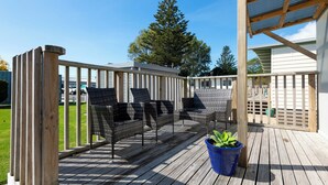 A wooden deck with outdoor seating and a potted plant.