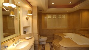 Un baño lujoso con un espejo grande, dos lavamanos, una bañera y un inodoro.