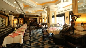 Un restaurante con una larga mesa de comedor, varias zonas de estar y una estatua.
