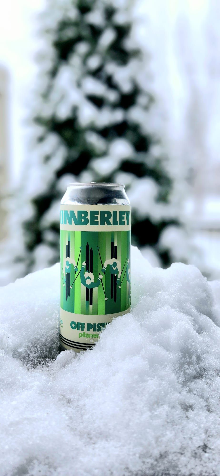 A can of 'Tinberley' beer with a green and white label, placed on snow.