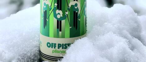 A can of 'Tinberley' beer with a green and white label, placed on snow.