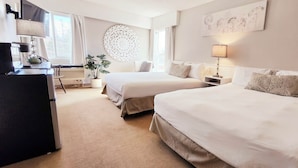 A hotel room with two beds, a desk, a lamp, a potted plant, and a wall decoration. - Western Lodge (Kimberley)