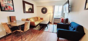 Familie suite, 1 slaapkamer | Woonruimte | Een 42-inch ledtelevisie met kabelzenders en televisie