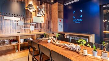 A modern kitchen with wooden accents, a large island with chairs, and a digital screen displaying 'FOCUS KURAMA'.