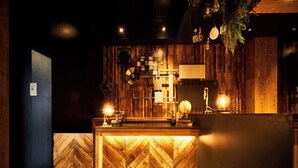 A reception desk with a wooden herringbone floor, a globe, and a lamp on the counter. - FOCUS Kuramae - Hostel (Tokyo)