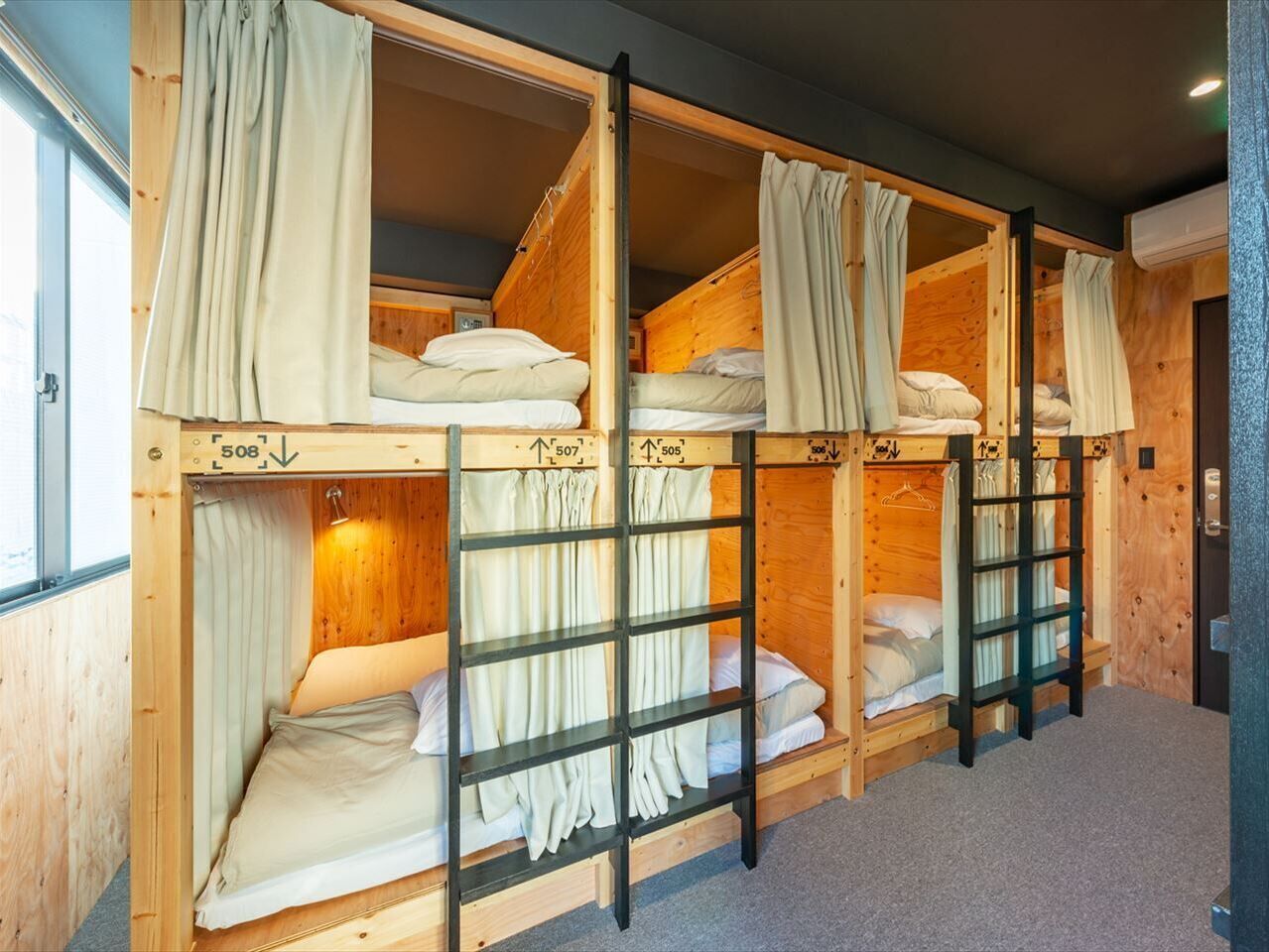 A room with bunk beds, wooden walls, and curtains.