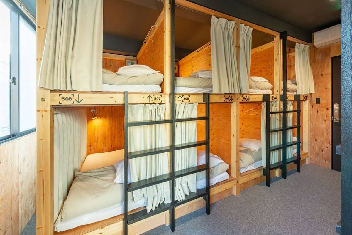 Una habitación con literas, paredes de madera y cortinas.
