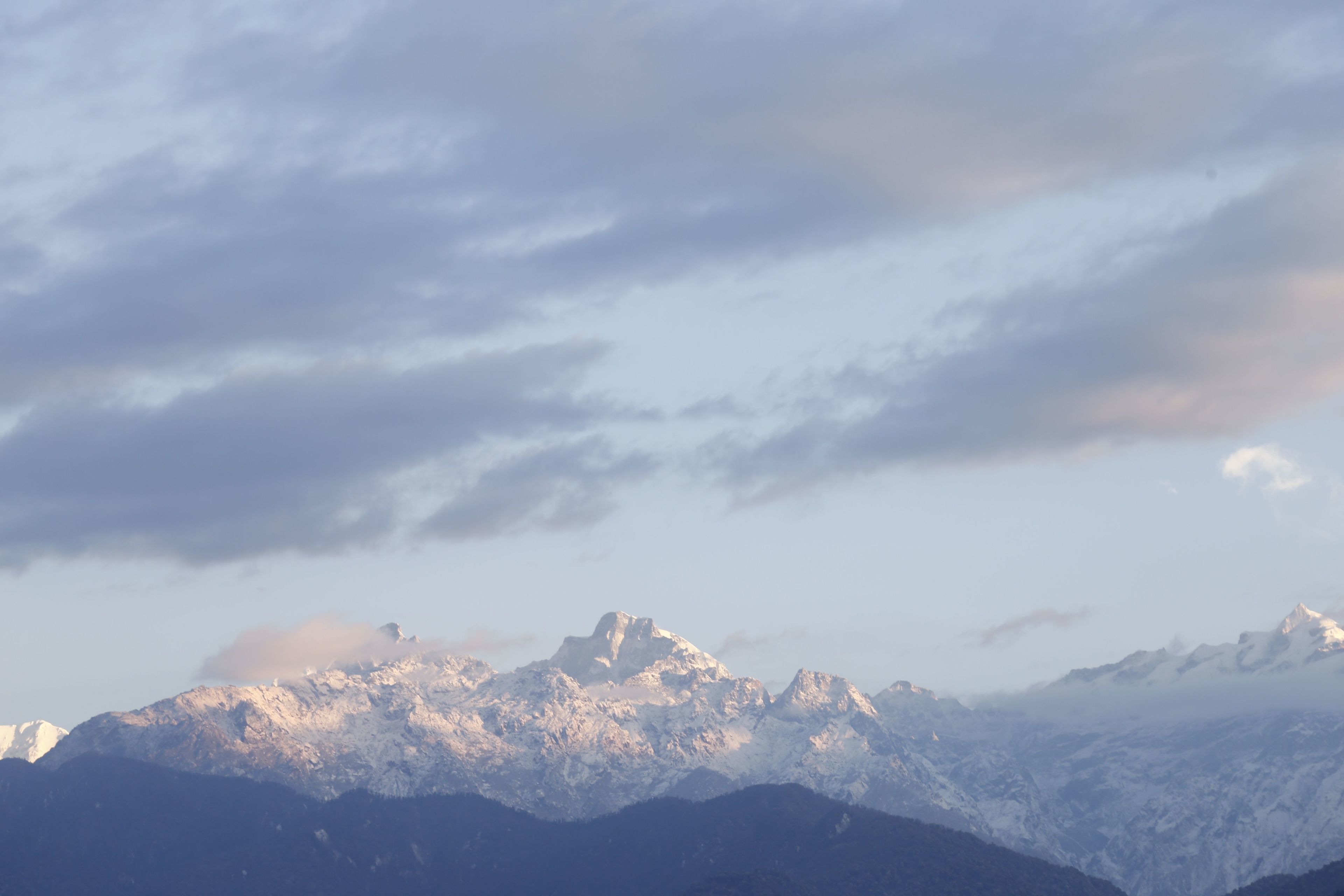 A mountain range with snow-covered peaks and a clear sky.