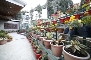 A tourist center with a signboard, potted plants, and a staircase leading to a building. - Hotel Sikkim Tourist Centre (Gyalshing)