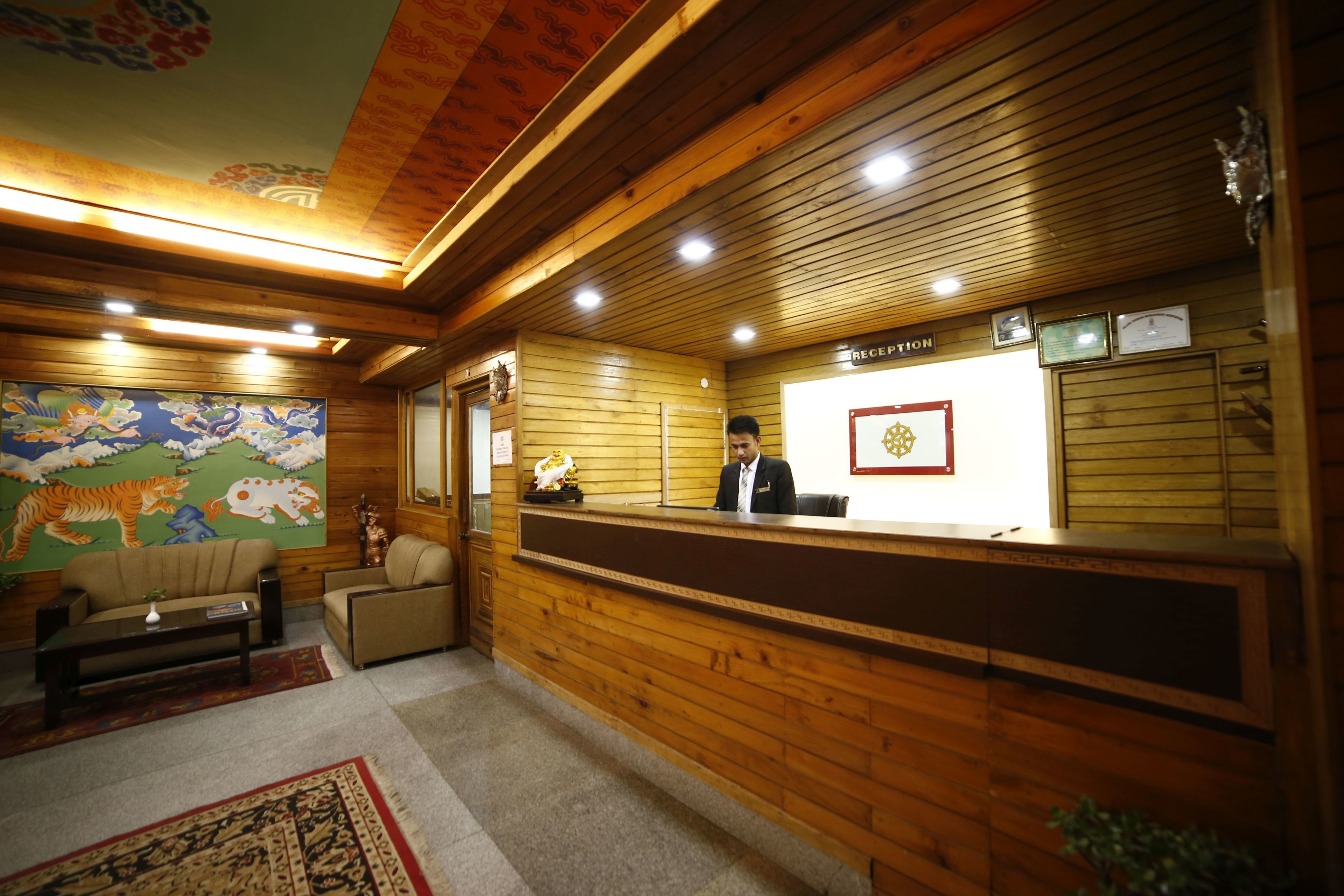 A wooden reception area with a reception desk, a sofa, a coffee table, and a mural on the wall.